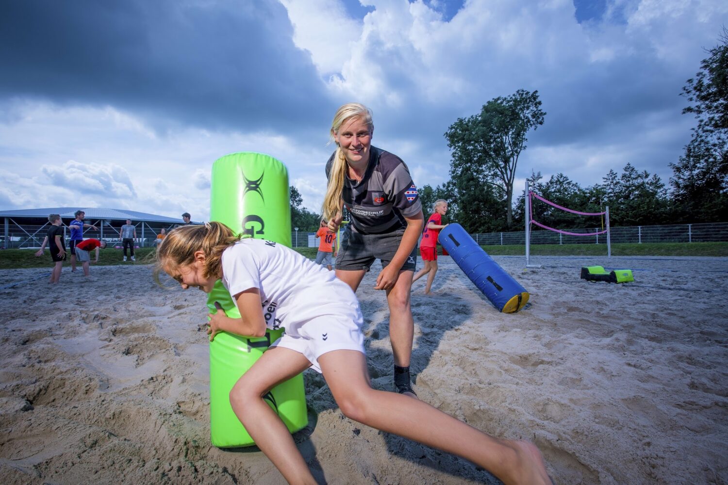 Kinderen spelen rugby op een strand in Friesland